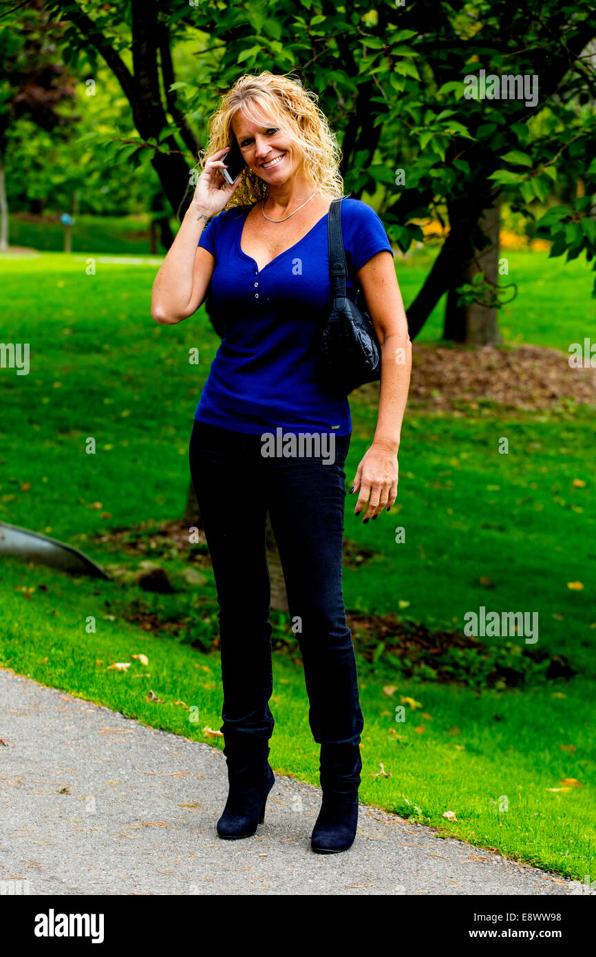 Modèle féminin en vêtements décontractés talking on cell phone Banque D'Images