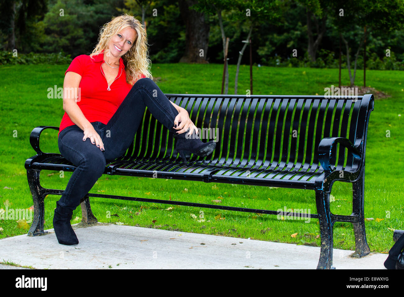 Modèle féminin en casual clothing sitting on bench Banque D'Images