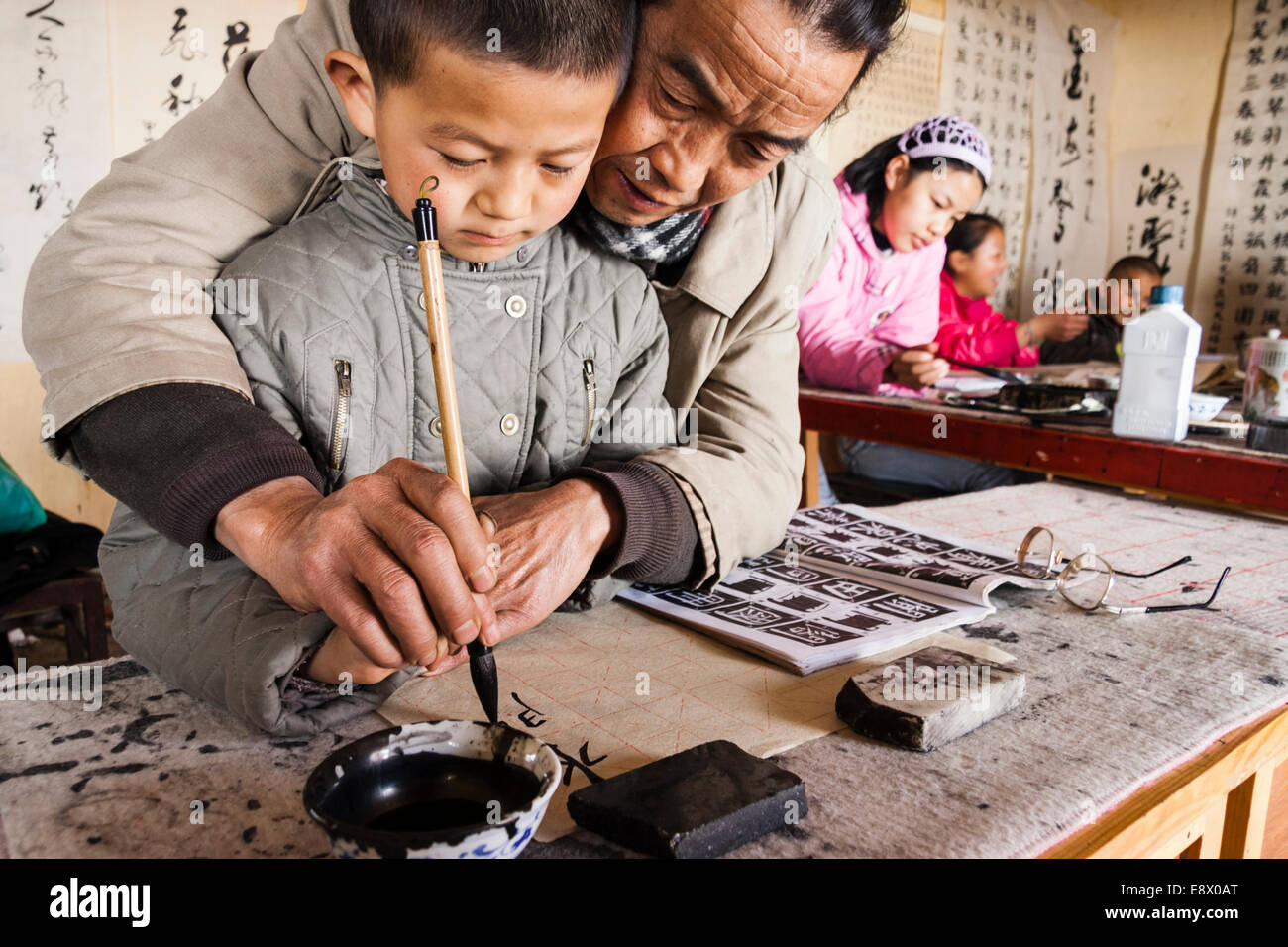 Professeur et élève à l'école de calligraphie traditionnelle. Lijiang, Chine Banque D'Images