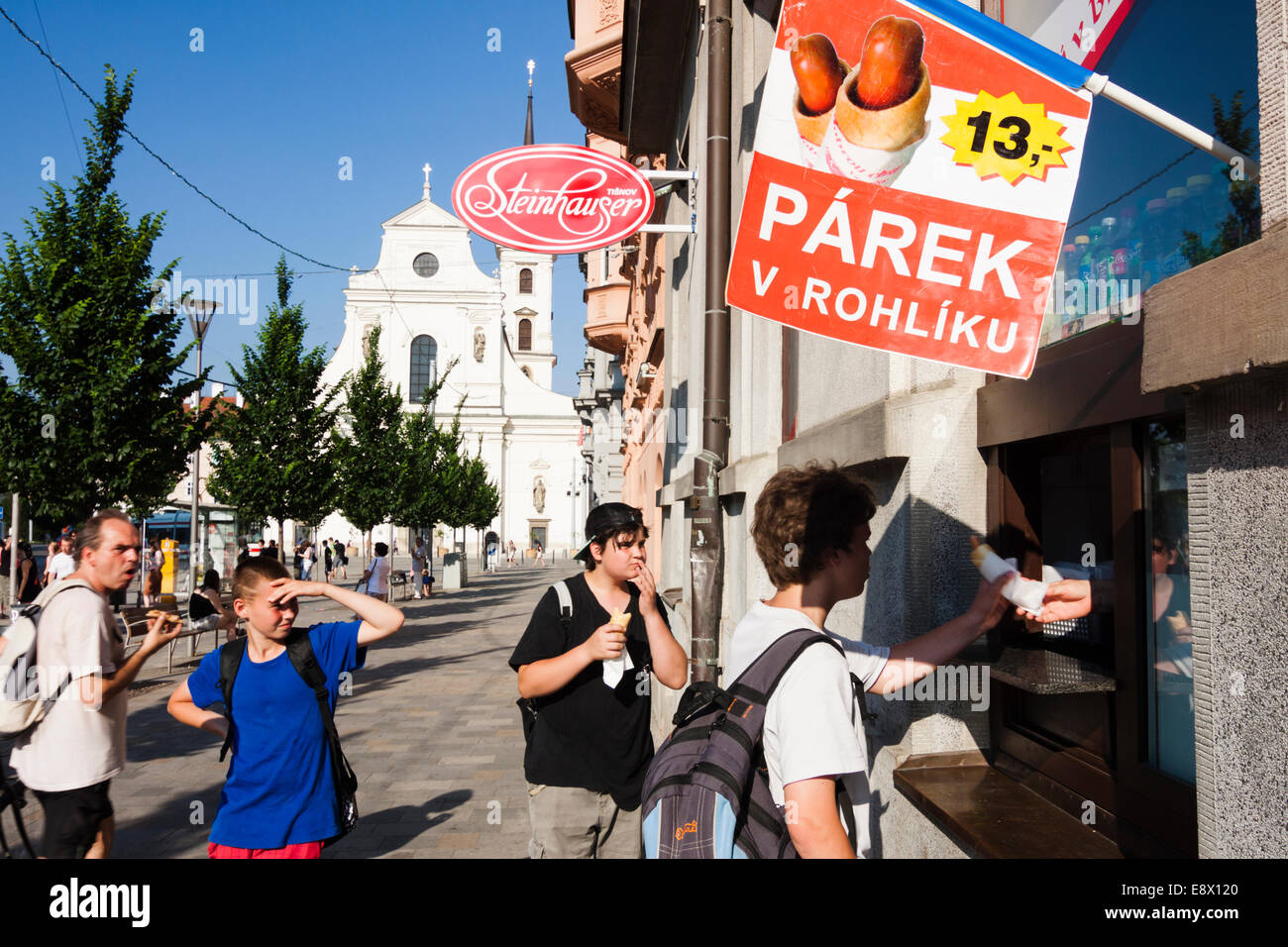 L'achat d'adolescents tchèque des hot-dogs à la rue Fibichova avec église de Saint Thomas en arrière-plan. Brno, République Tchèque Banque D'Images