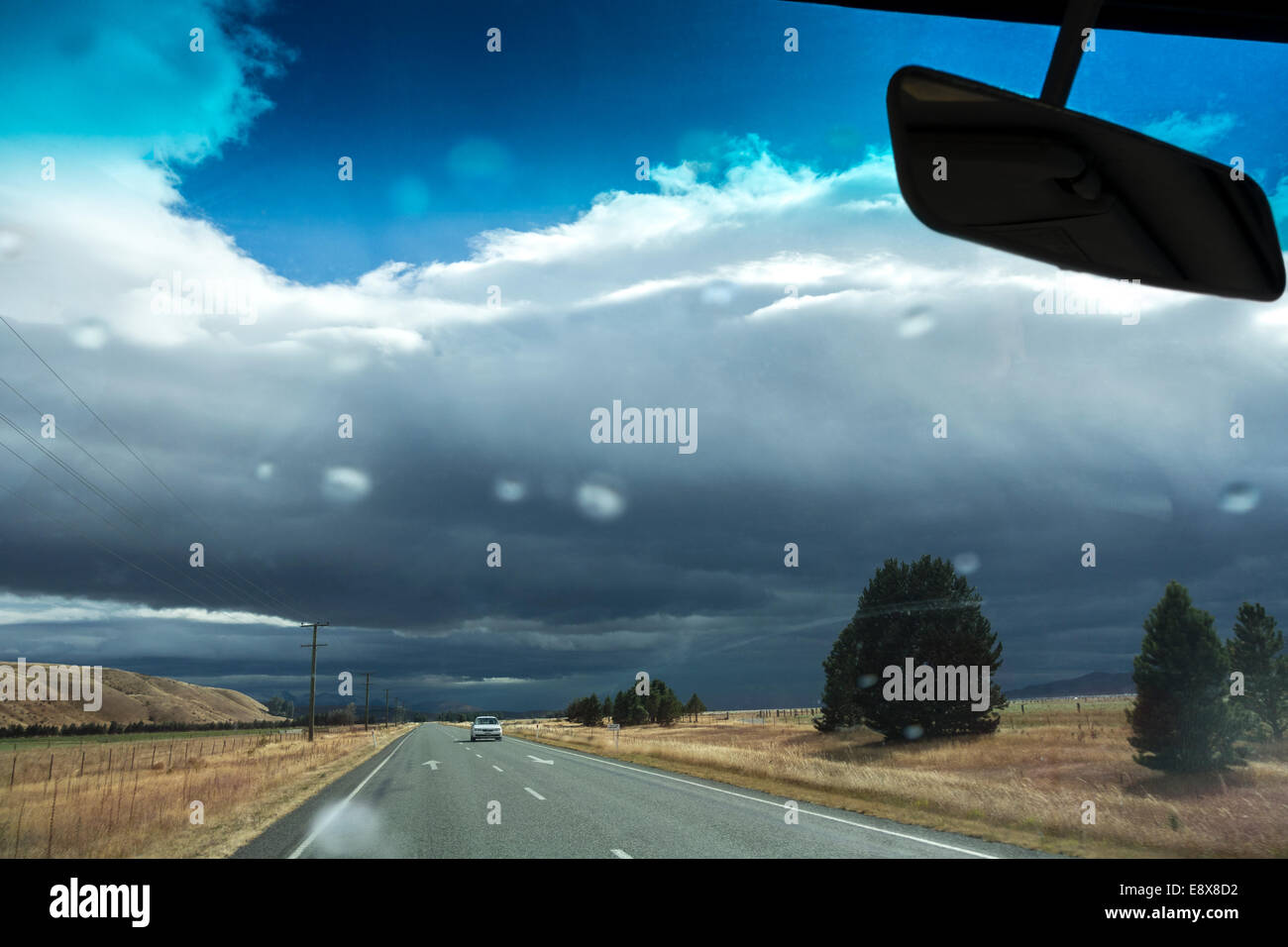 Nouvelle Zélande météo peuvent être imprévisibles. Dans la conduite d'une averse sur la route 8 près de Omarama. Les premières gouttes de pluie sur le pare-brise Banque D'Images