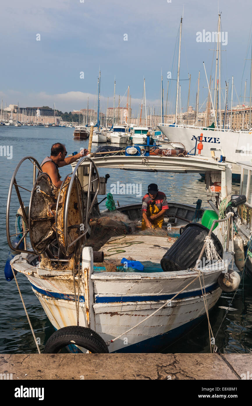 Deux pêcheurs s'occupant de leurs filets sur le marché aux poissons quotidien de Marseille dans le vieux port Banque D'Images