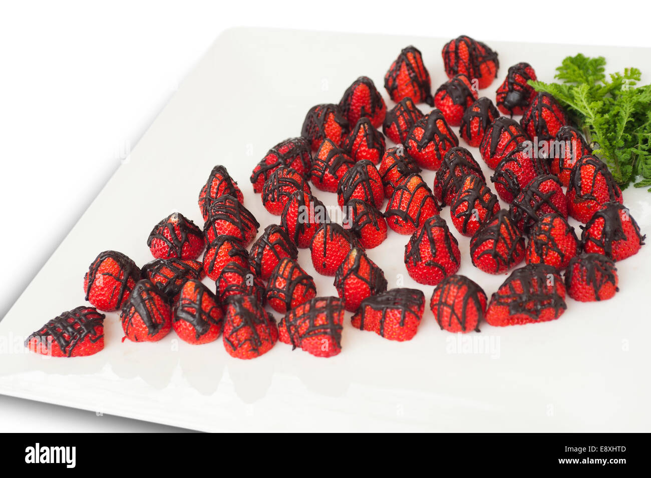 De fraises enrobées de chocolat sur le bac, sur fond blanc Banque D'Images