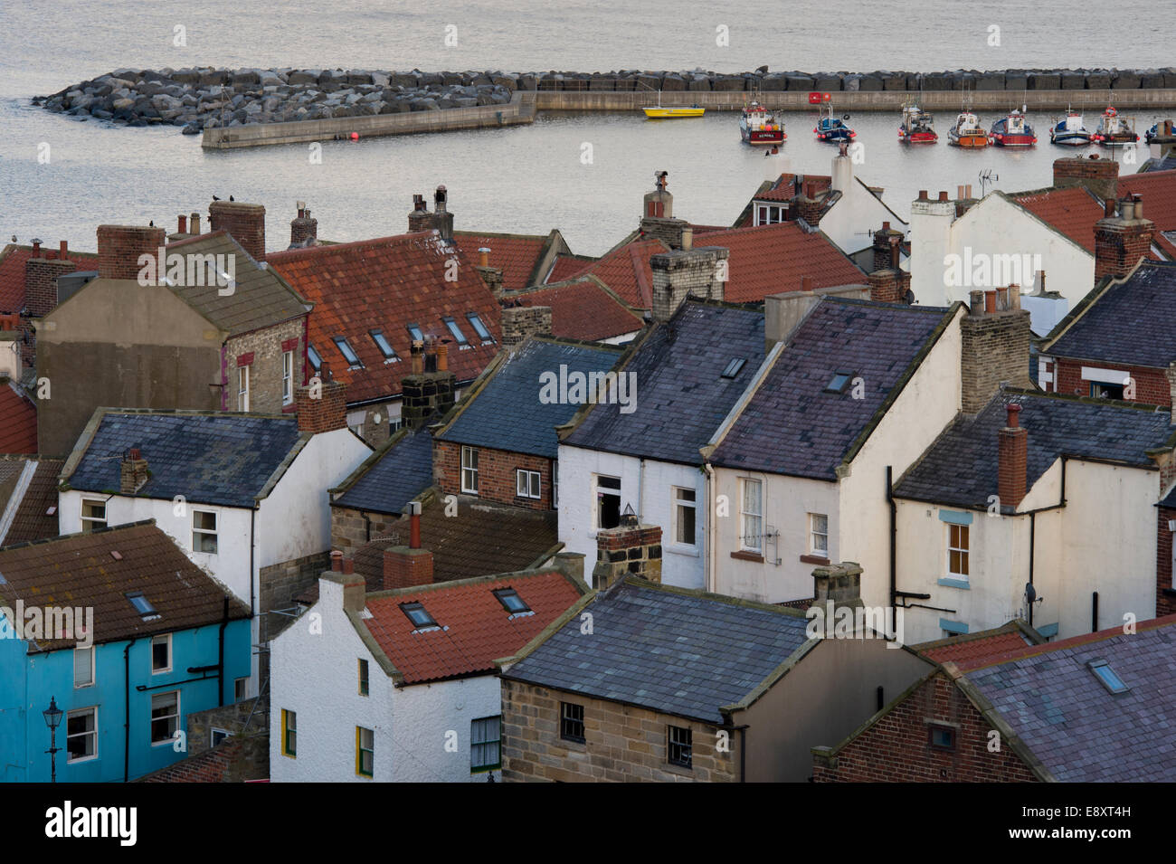 Vue de haut sur les toits de petite et pittoresque des chalets, de bateaux dans le port et la mer au-delà - village balnéaire de Staithes, North Yorkshire, Angleterre, Royaume-Uni. Banque D'Images