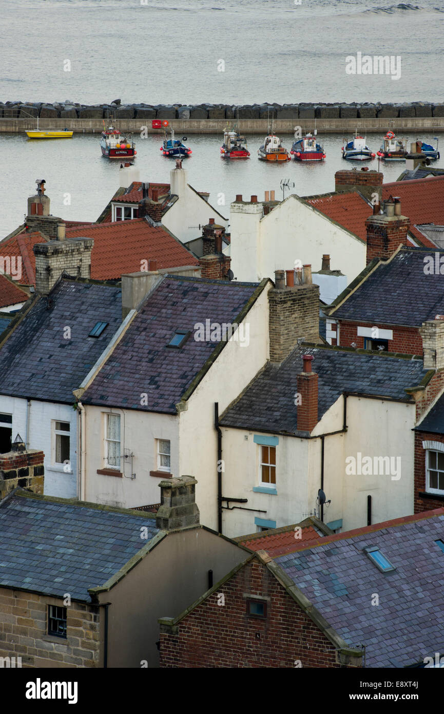 Vue de haut sur les toits de petite et pittoresque des chalets, de bateaux dans le port et la mer au-delà - village balnéaire de Staithes, North Yorkshire, Angleterre, Royaume-Uni. Banque D'Images