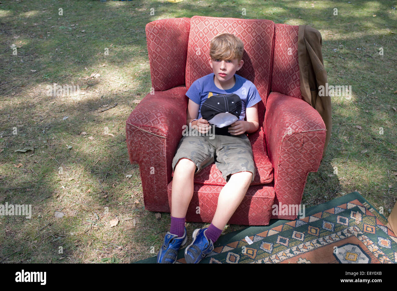 Boy sitting in armchair Banque D'Images