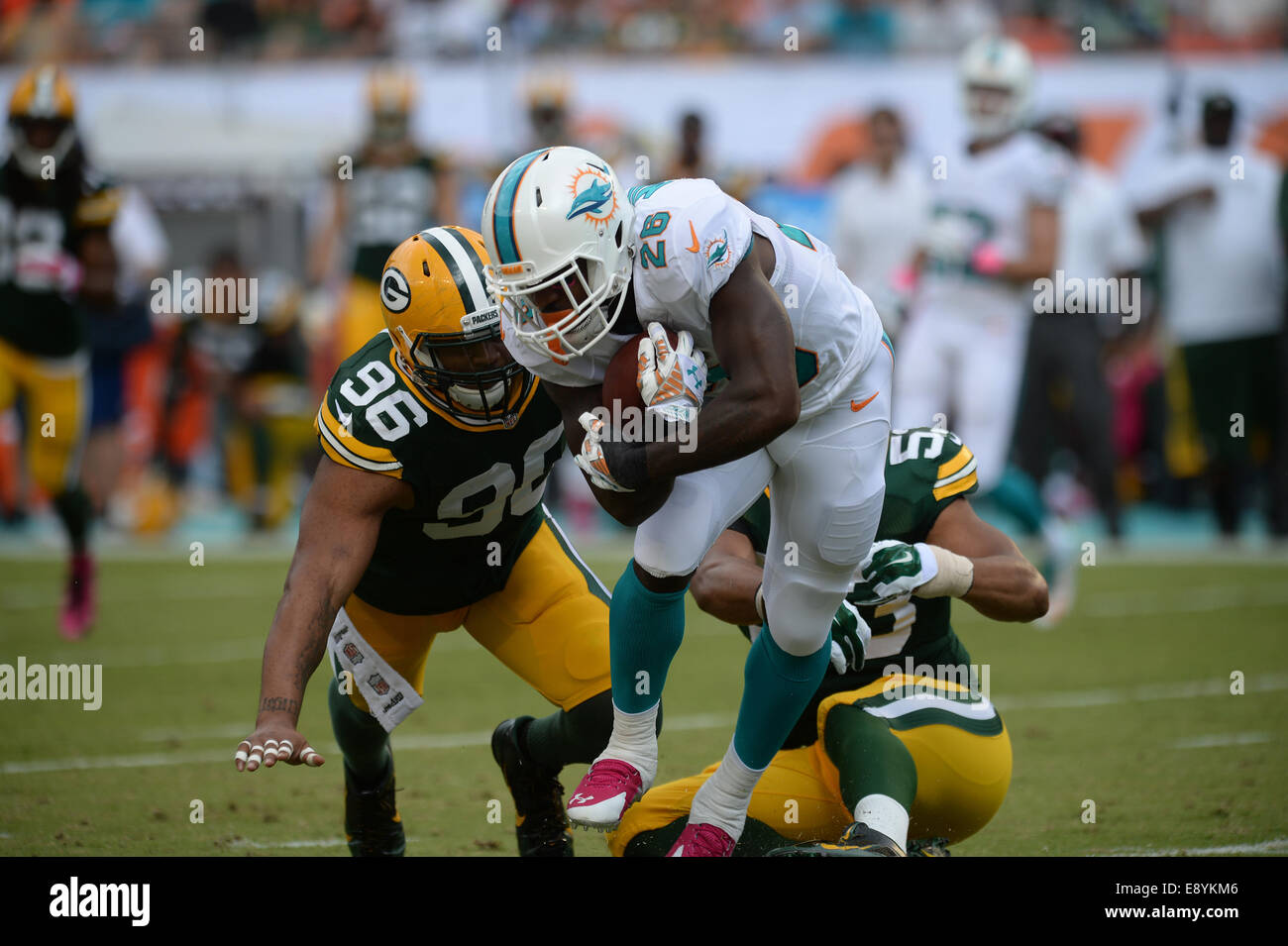 Jardins de Miami en Floride, USA. 12 octobre, 2014. Mike Neal # 96 et Nick Perry # 53 de Green Bay tentative de s'attaquer à Lamar Miller # 26 de Miami au cours de la NFL football match entre les dauphins de Miami et de Green Bay Packers au Sun Life Stadium de Miami Gardens FL. Les Packers défait les dauphins 27-24. © csm/Alamy Live News Banque D'Images