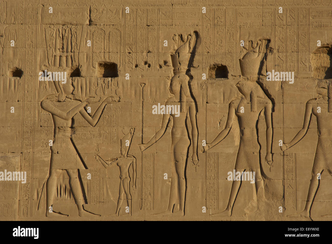 L'Egypte Art. Dendérah. Temple d'Hathor. Le dieu Ihy, que adulte, faire des offrandes devant un petit chiffre d'Ihy, Hathor et Horus. Banque D'Images