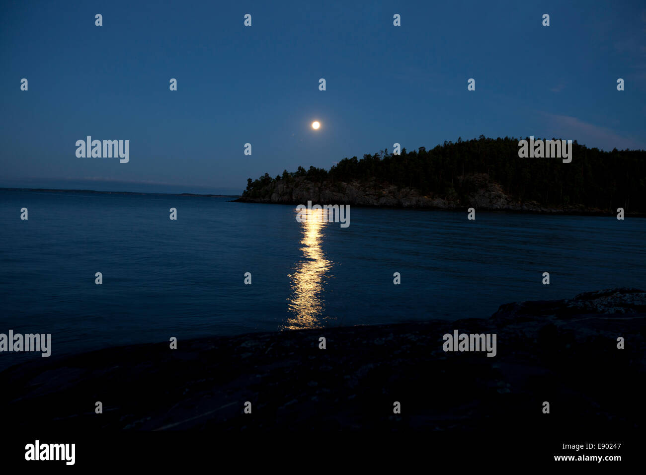 La lune se reflétant dans une mer bleue Banque D'Images