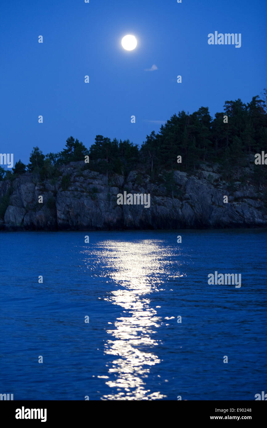 La lune se reflétant dans une mer bleue Banque D'Images