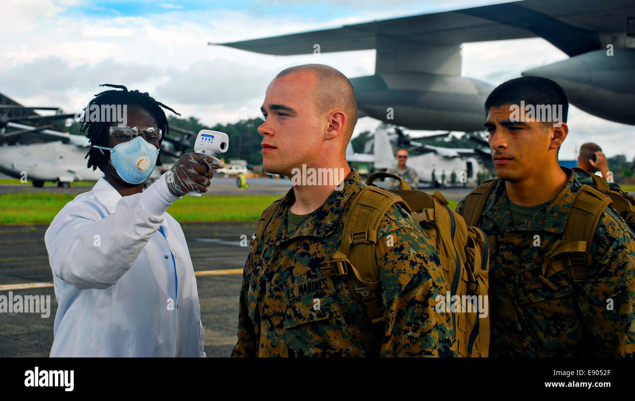 Les Marines américains de la Task Force Maritime Aérien Au sol, obtenir leur réponse aux crises de vérifier la température en sortie d'un avion de transport KC-130 à l'arrivée le 9 octobre 2014 à Monrovia, au Libéria. Les Marines vont aider à la construction d'unités de traitement de l'Ebola dans le plus difficile d'atteindre les régions du Libéria dans un effort pour contenir l'épidémie du virus Ebola en Afrique occidentale. Banque D'Images