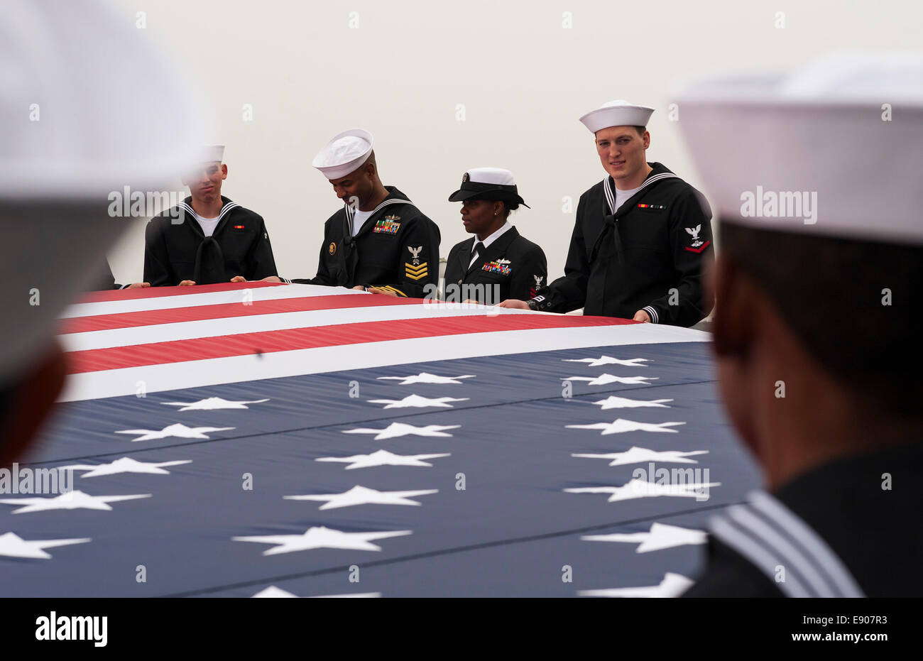 Les marins américains affectés au navire d'assaut amphibie USS America (LHA 6) tenir un drapeau américain pour une photo aérienne comme le navire passe sous le Golden Gate Bridge au cours d'une escale prévue pour la 34e Semaine annuelle de 6 octobre 2014, à San Francisco, Cali Banque D'Images
