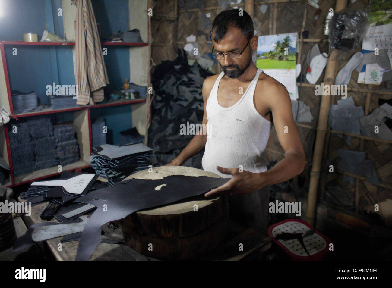 Dhaka, Bangladesh. 14Th Oct, 2014. Un travailleur du Bangladesh coupe le traité pour faire mousser ses chaussures à Hazaribagh. Dhaka, Bangladesh © Suvra Kanti Das/ZUMA/ZUMAPRESS.com/Alamy fil Live News Banque D'Images