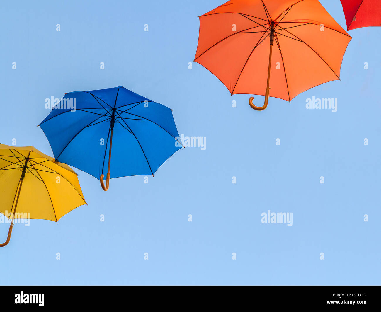 Flottant parasols colorés contre un ciel bleu Banque D'Images