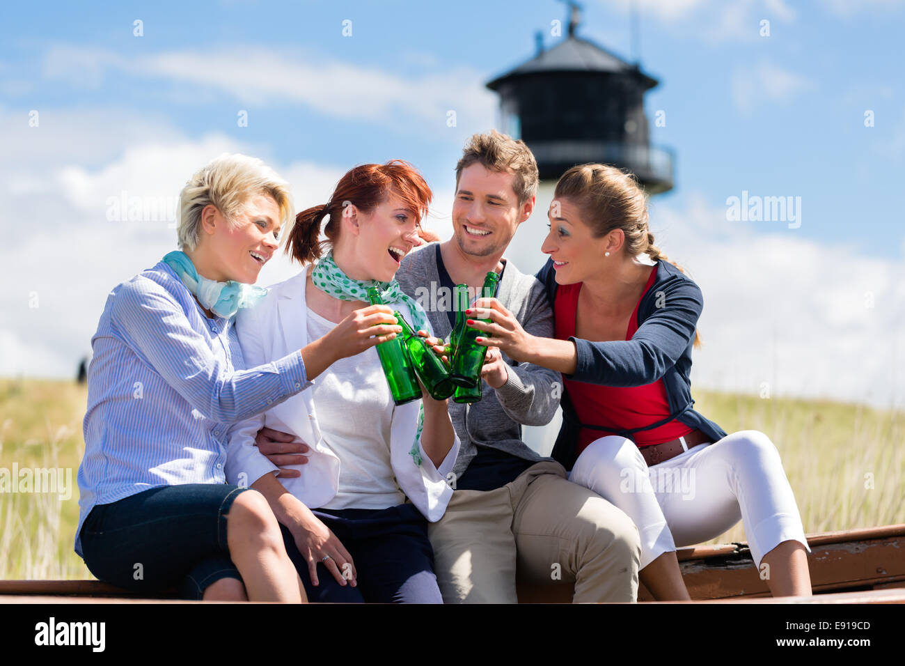 Les amis de boire la bière en bouteille appréciant des vacances à la plage de la mer du nord allemande Banque D'Images