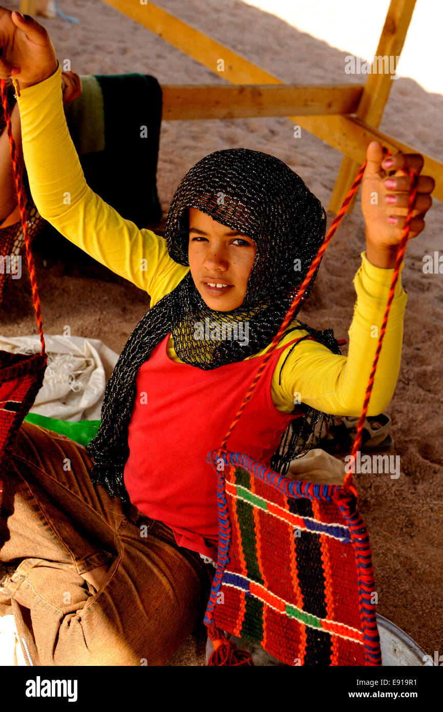 Les jeunes arabes bédouines girl holding up hand crafted bag à vendre à camp bédouin dans le désert du Sinaï du sud Banque D'Images
