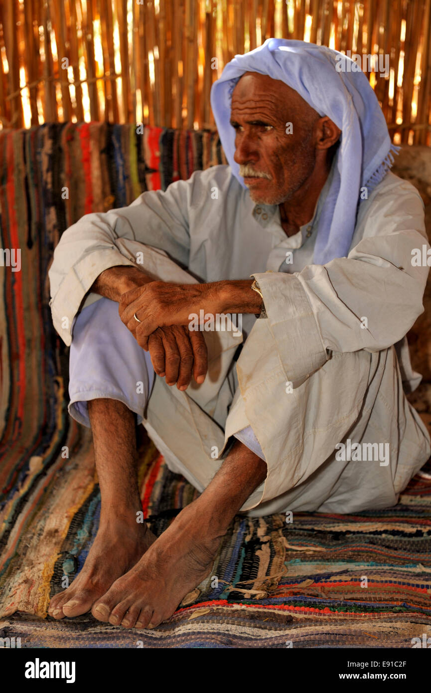 Les hommes bédouins assis sur des tapis traditionnels Banque D'Images