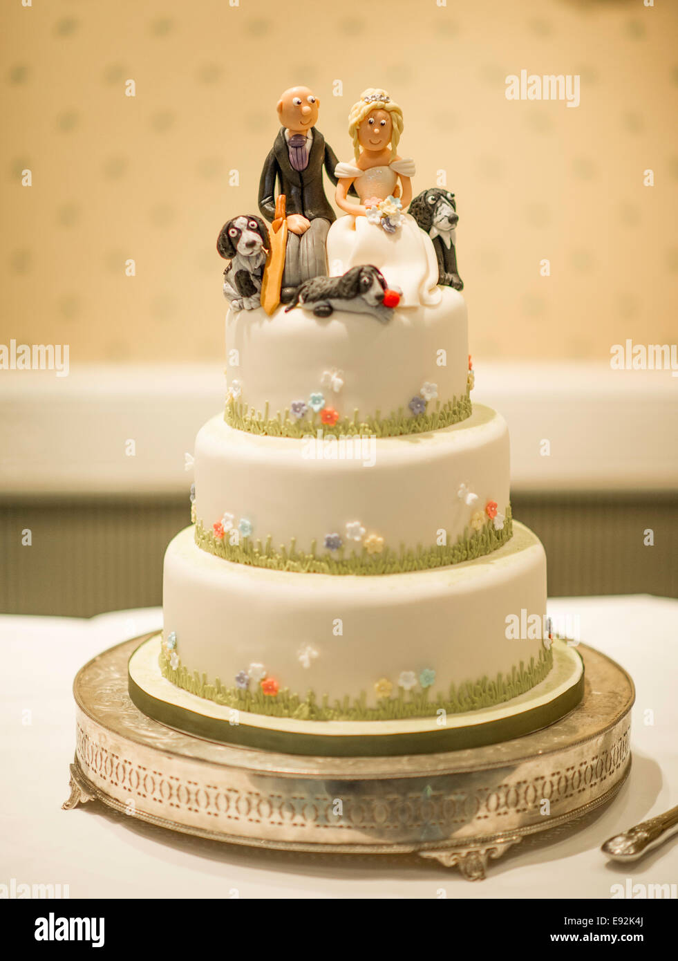 Gâteau de mariage avec couple sur le dessus et les chiens Banque D'Images