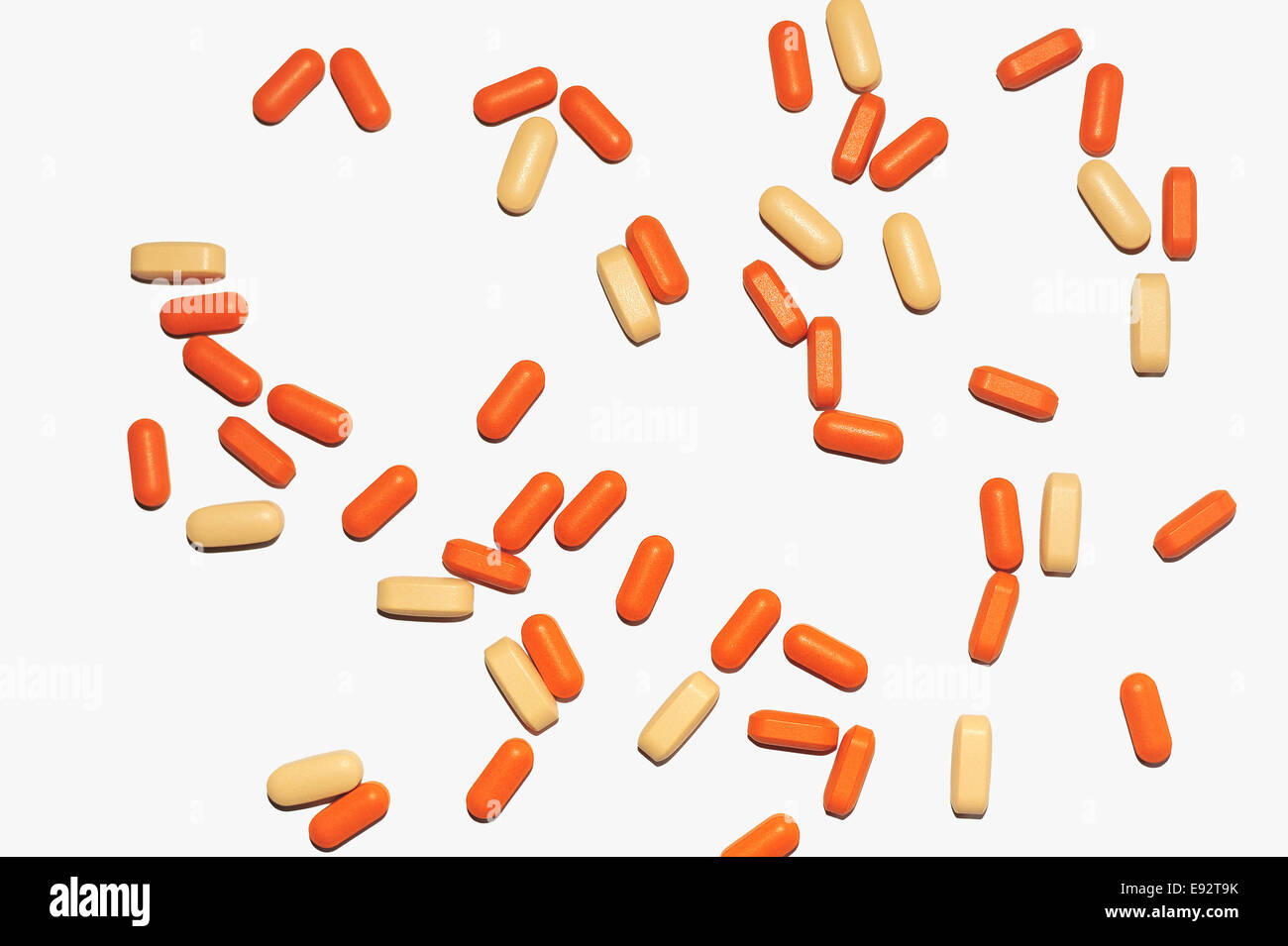 Une image d'un lâche quelques pilules médical orange et jaune sur un fond blanc. Banque D'Images