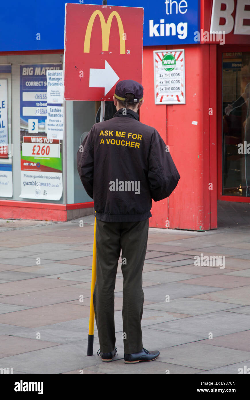 Les employés de McDonald's avec bandeau publicitaire de rue, England, UK Banque D'Images
