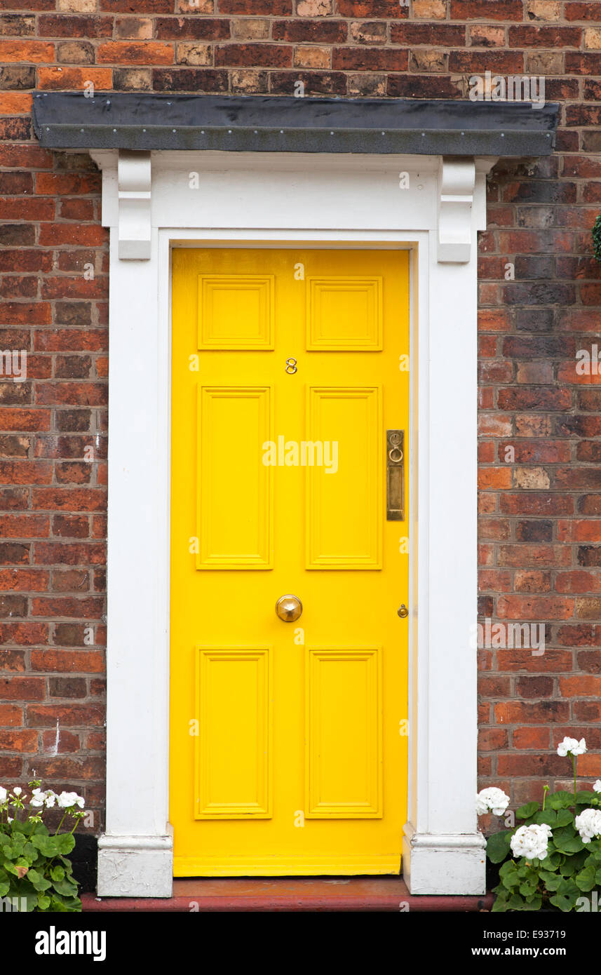 Cottage en brique avec porte jaune, England, UK Banque D'Images