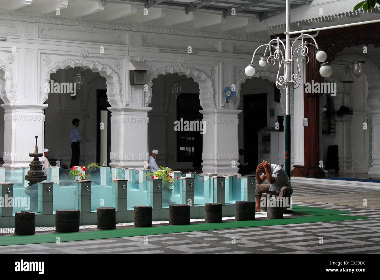 Un homme se lave avant de prier à la Jummah Masjid (mosquée) à Port Louis, Ile Maurice Banque D'Images