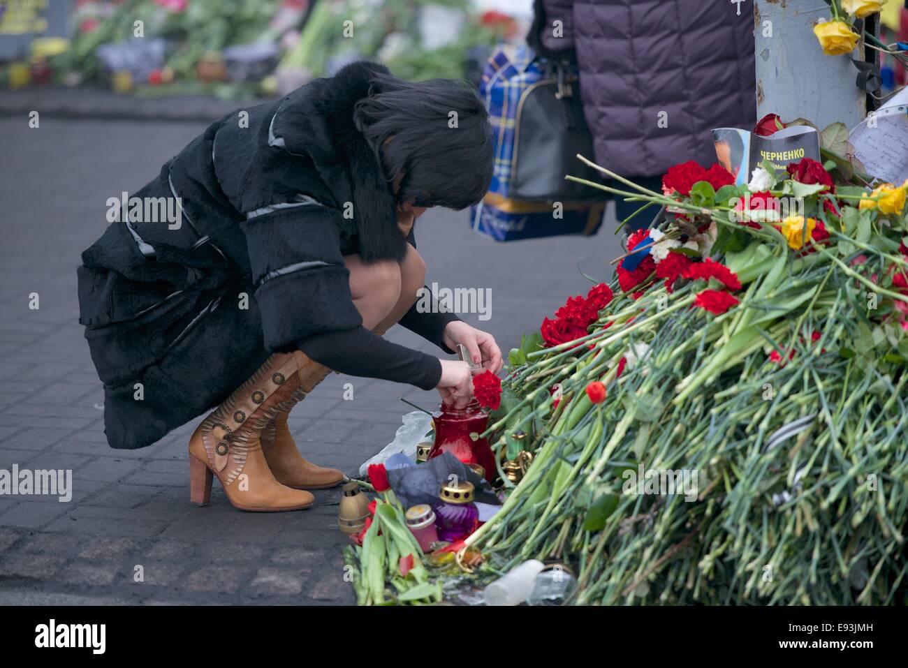 Une femme allume une bougie sur un monument aux morts, Maidan Kiev Banque D'Images