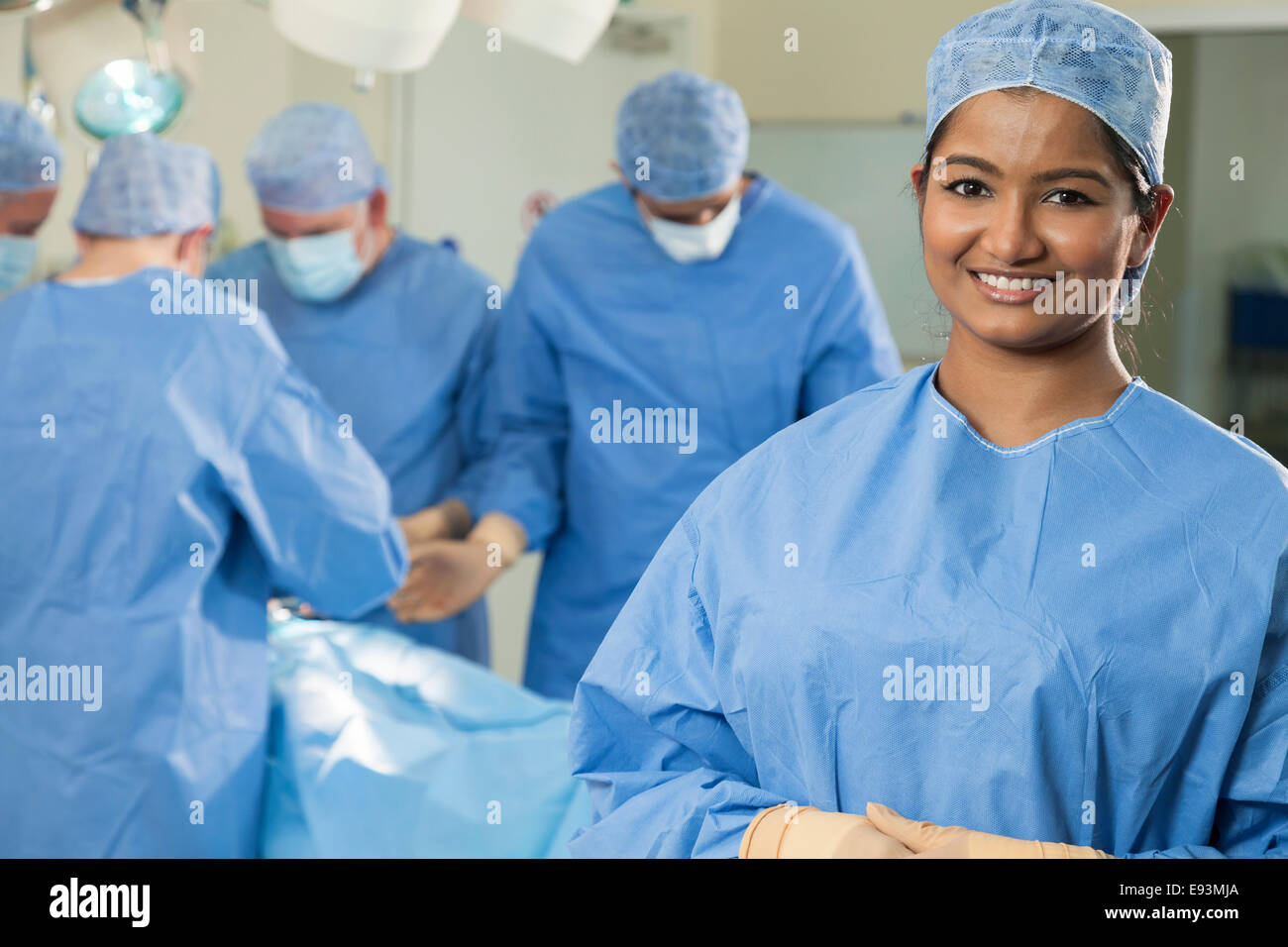 Young Asian Indian female femme infirmière médecin chirurgien avec son équipe chirurgicale interracial travaillant sur un patient en chirurgie de l'hôpital Banque D'Images