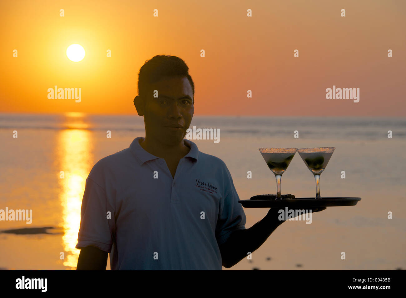 Serveur qui sert des cocktails au coucher du soleil l'Indonésie Lombok Gili Air Banque D'Images