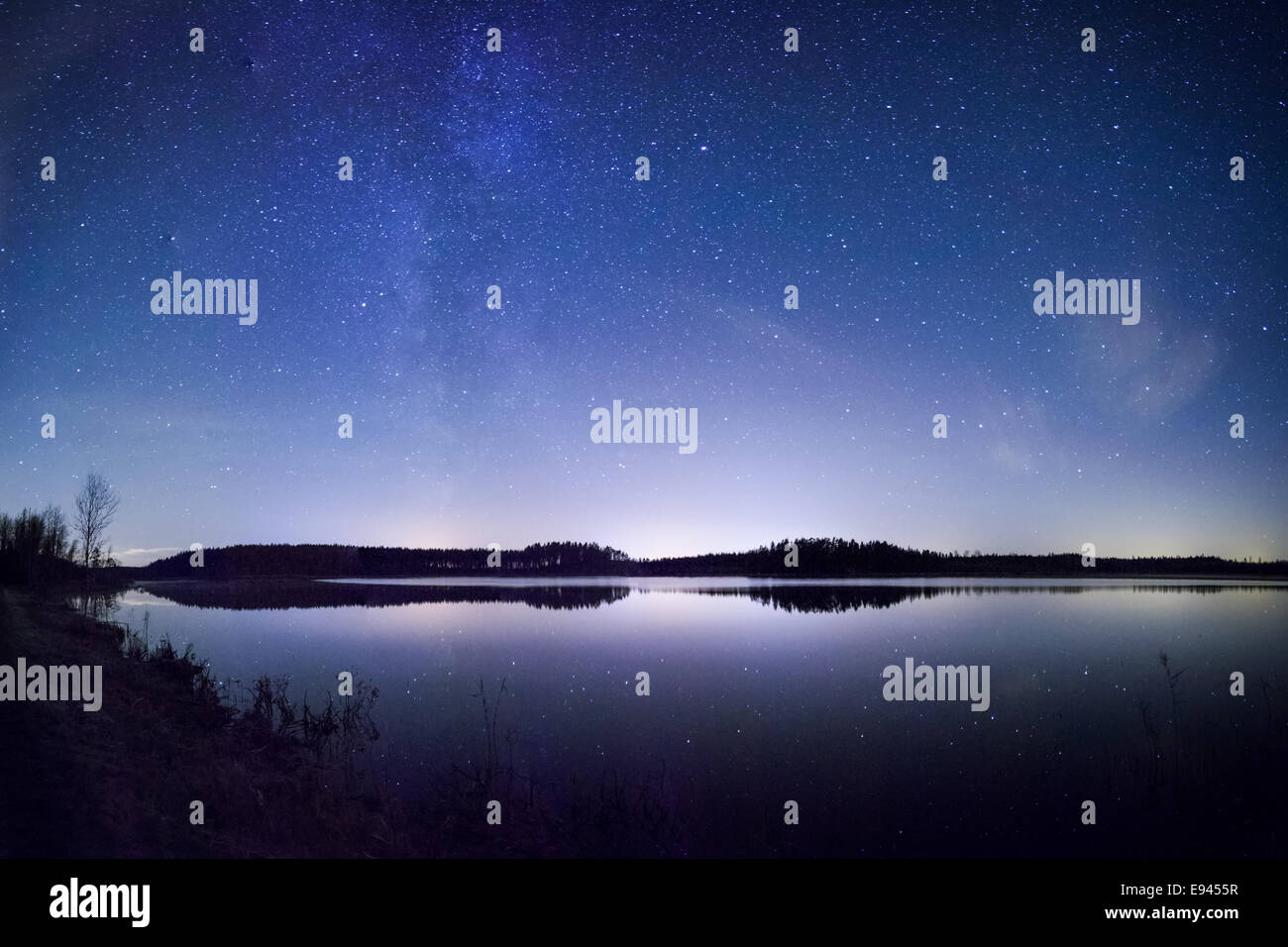 Voie Lactée lumineuse sur le lac de nuit en Finlande. Banque D'Images Voie Lactée lumineuse sur le lac de nuit en Finlande. Banque D'Images