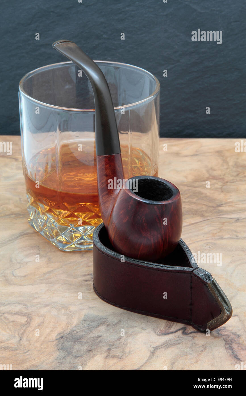 Pipe en bois et verre de whisky sur une table en bois Banque D'Images