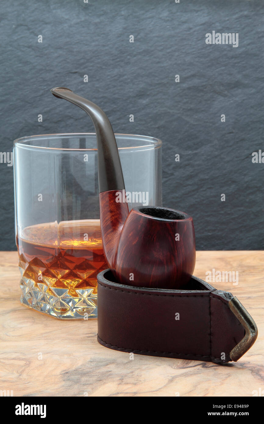 Pipe en bois et verre de whisky sur une table en bois Banque D'Images