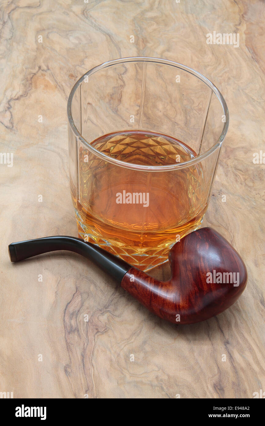 Pipe en bois et verre de whisky sur une table en bois Banque D'Images