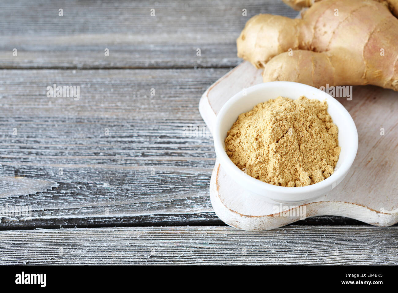 Le gingembre en poudre dans un bol on cutting board Banque D'Images