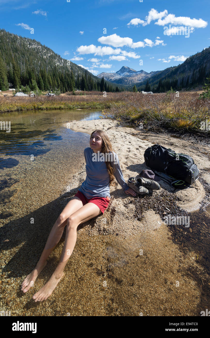 Backpacker détendre et profiter ses pieds dans un ruisseau dans l'Oregon est Montagnes Wallowa. Banque D'Images