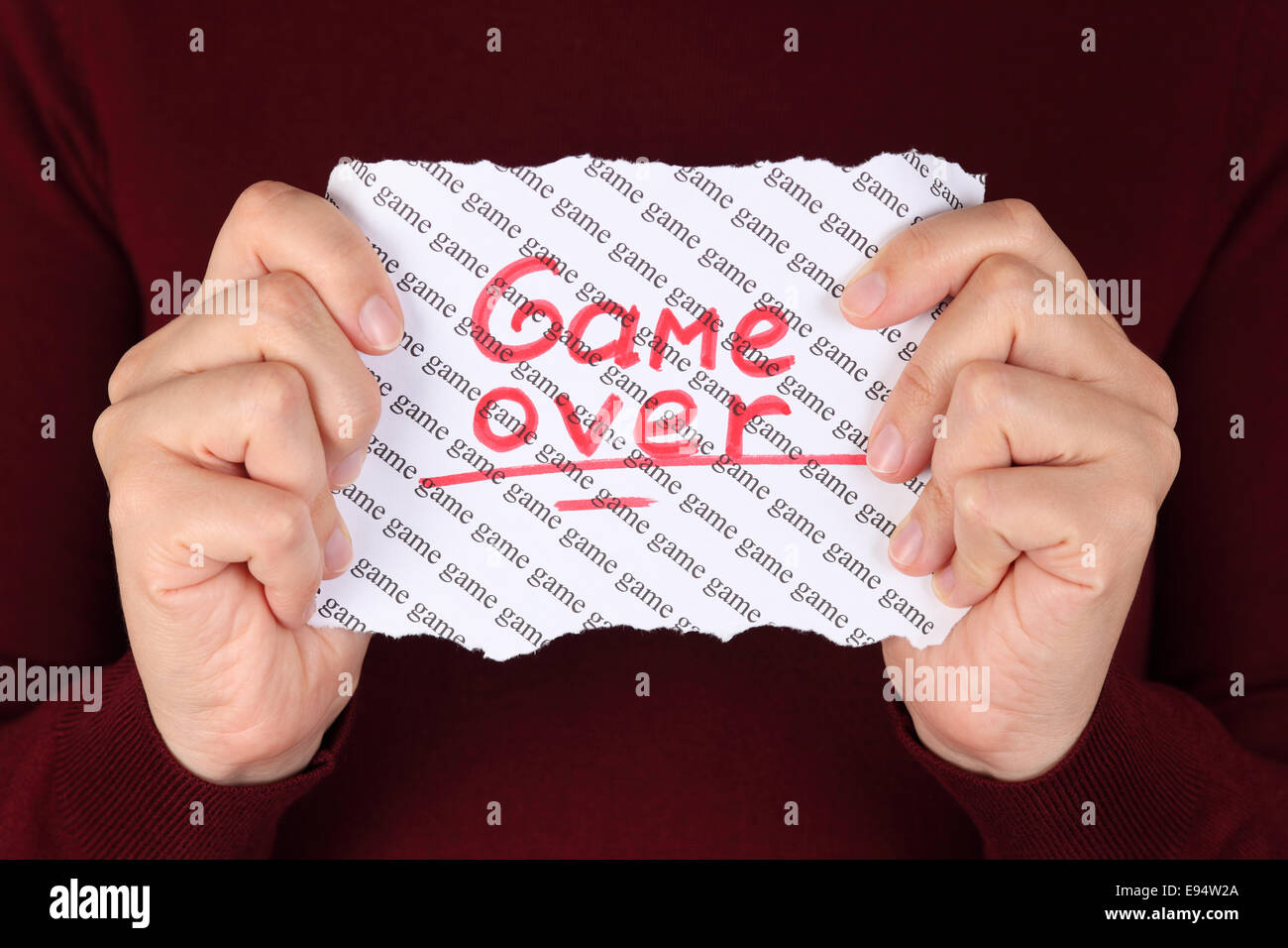 Morceau de papier rouge avec mot 'game over' sur l'arrière-plan avec les mots 'jeu' dans les mains de la femme. Banque D'Images