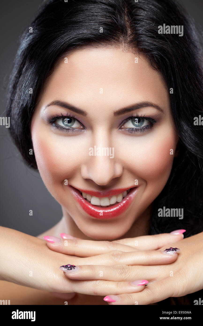Belle jeune femme avec une peau parfaite et des ongles Banque D'Images