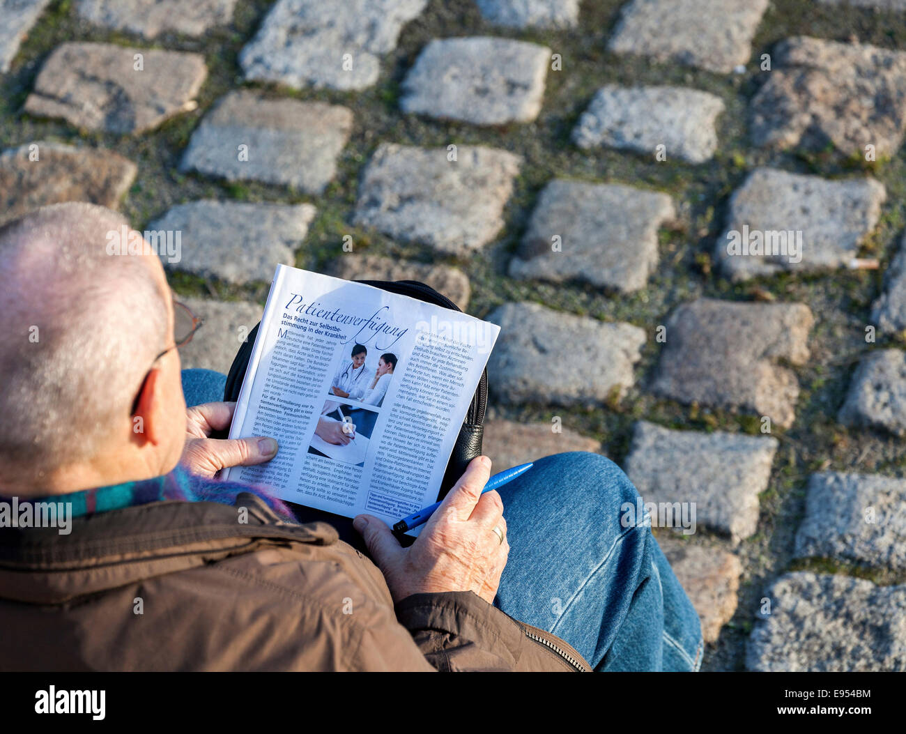 Vieillard assis sur un banc, l'étude d'une brochure pour faire un "Patientenverfügung', l'allemand pour "vivre", Berlin Banque D'Images