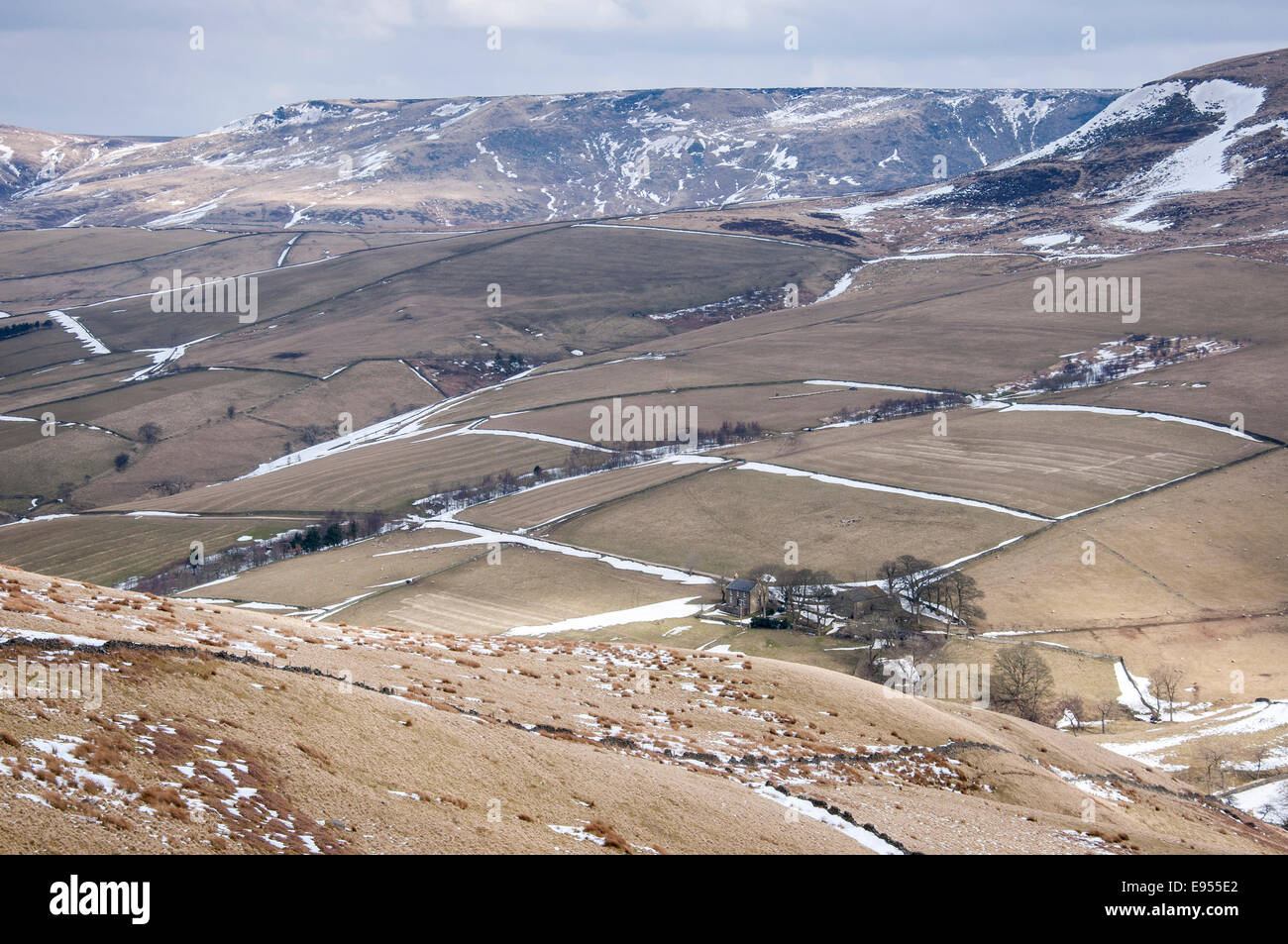 Pentes sous Kinder Scout à la fin de l'hiver avec des traces de neige à côté des murs de pierre. Banque D'Images