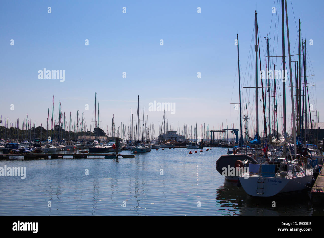 Une 'forêt' de location de mâts silhouetted against a blue sky, Lymington, Hampshire, England, UK. Banque D'Images