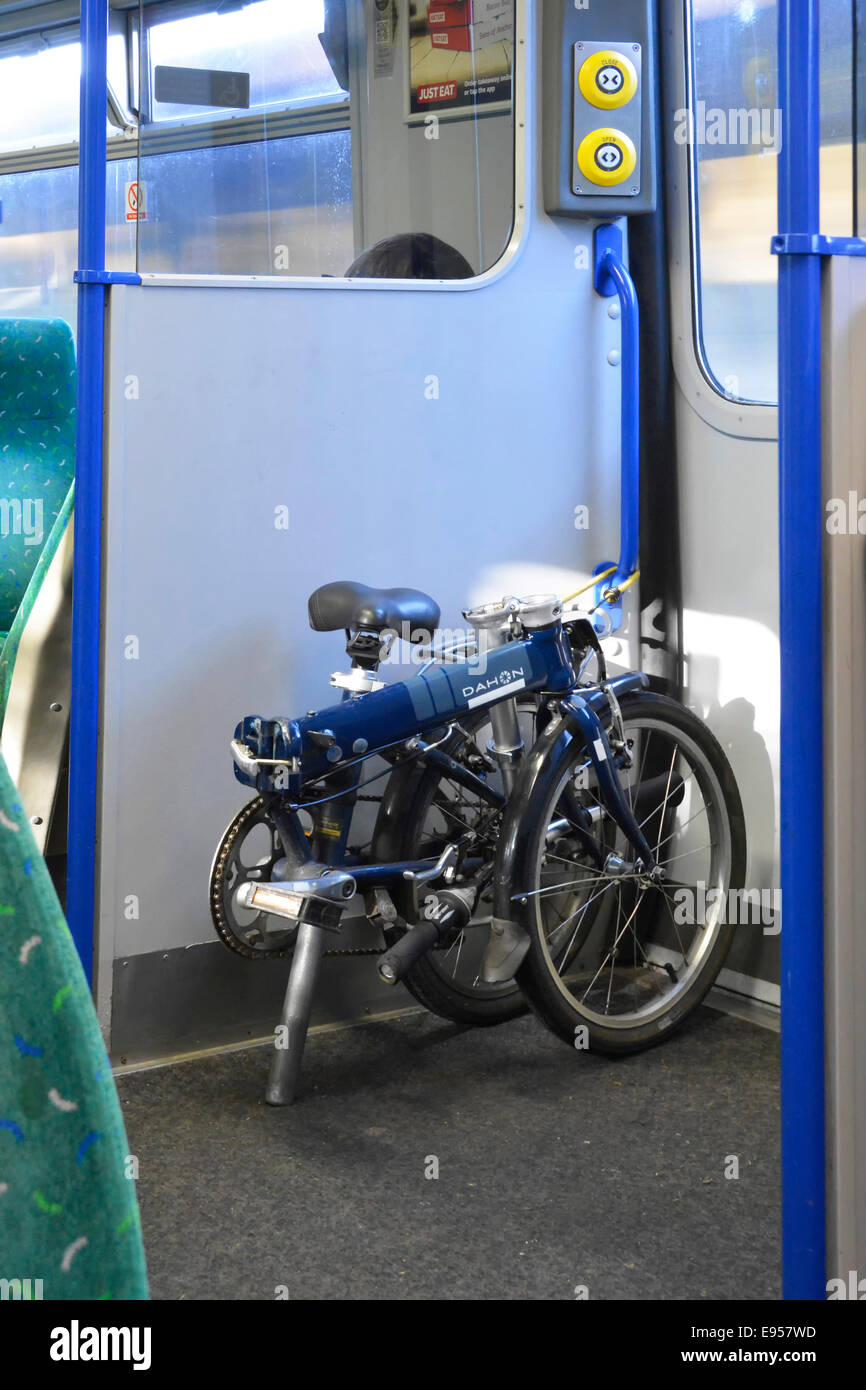 Vélo pliant Dahon placé à côté de la sortie des portes d'entrée à l'intérieur d'un train de banlieue transport voyageant en direction de Londres. Banque D'Images