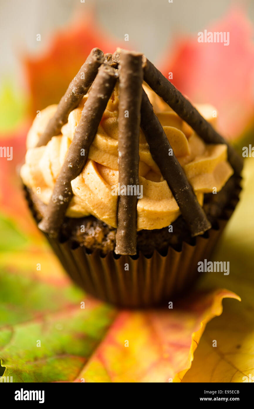 Cupcakes avec glaçage au chocolat orange swirl avec les doigts comme des billes Banque D'Images