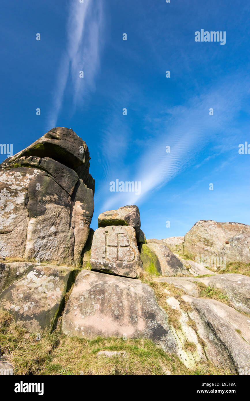 Des pierres à Robin Hoods enjambée au-dessous de ciel bleu profond et des nuages filandreux. Peak District, Derbyshire. Banque D'Images