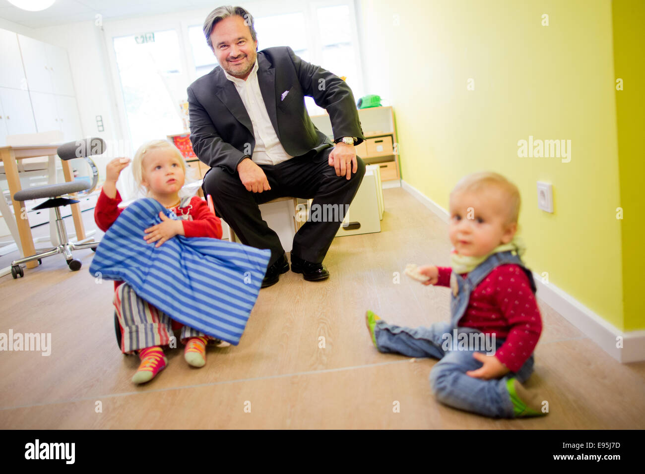 Cologne, Allemagne. 20 Oct, 2014. Le chef de la chaîne de supermarché REWE Group, Alain Caparros, se trouve entre les deux ans Ella (L) et le one-year-old Nora (R) à une crèche à Cologne, Allemagne, 20 octobre 2014. Caparros a ouvert la crèche pour ses enfants des employés, qui est censé faciliter la réalisation d'un équilibre travail-vie. Dpa : Crédit photo alliance/Alamy Live News Banque D'Images