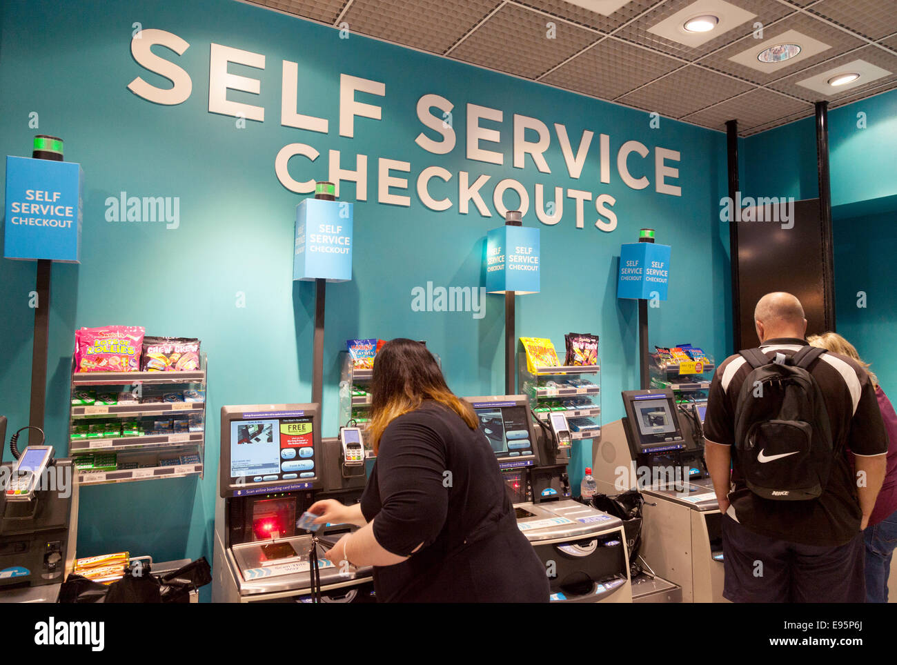 Les gens à l'aide de caisses libre-service, WH Smith, Gatwick Airport, Royaume-Uni Banque D'Images