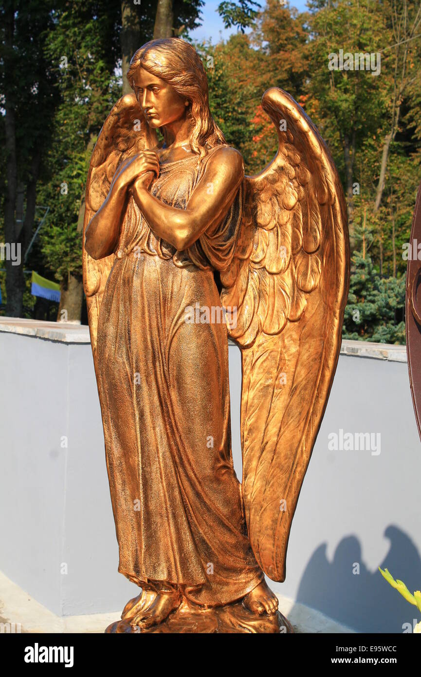 Statue de l'ange doré avec les mains en prière avec les ailes ouvertes Banque D'Images