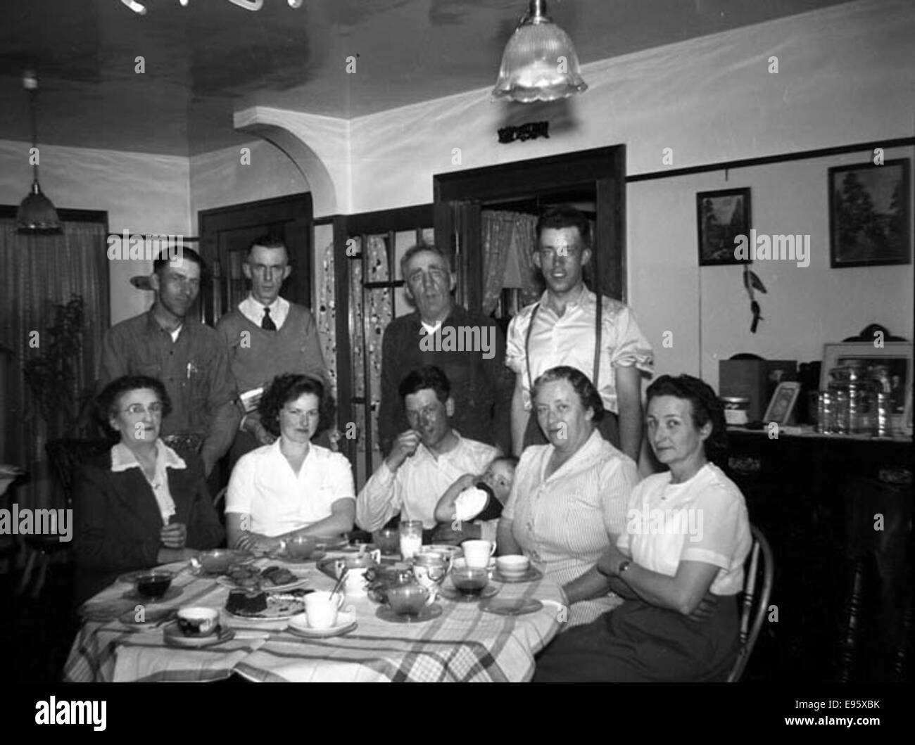 Groupe de personnes posant autour d'une table de dîner (À LA FERME). 18 avril 1948 21/4 x 31/4 c'est un négatif de 54 photos dans l'album "Fort Macleod's anonyme". La plupart sont tourné en Fort Macleod, Alberta à la fin 1940 Banque D'Images