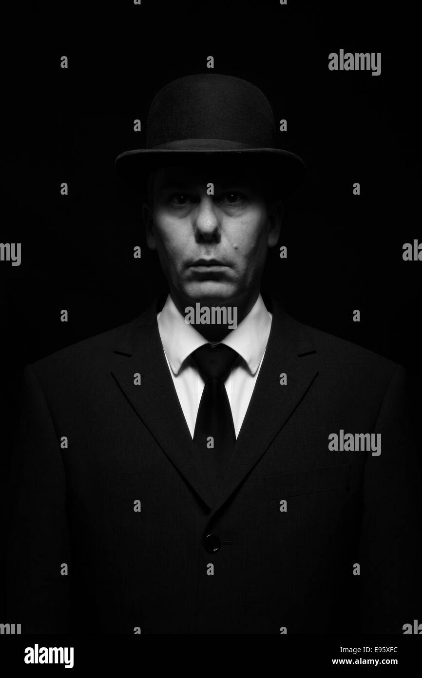 L'éclairage dramatique sur l'homme en costume et chapeau melon Banque D'Images