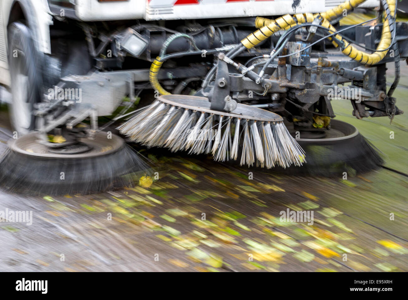 Nettoyage du chariot à mouvement rapide d'une rue à l'automne de feuilles mortes et la boue Banque D'Images