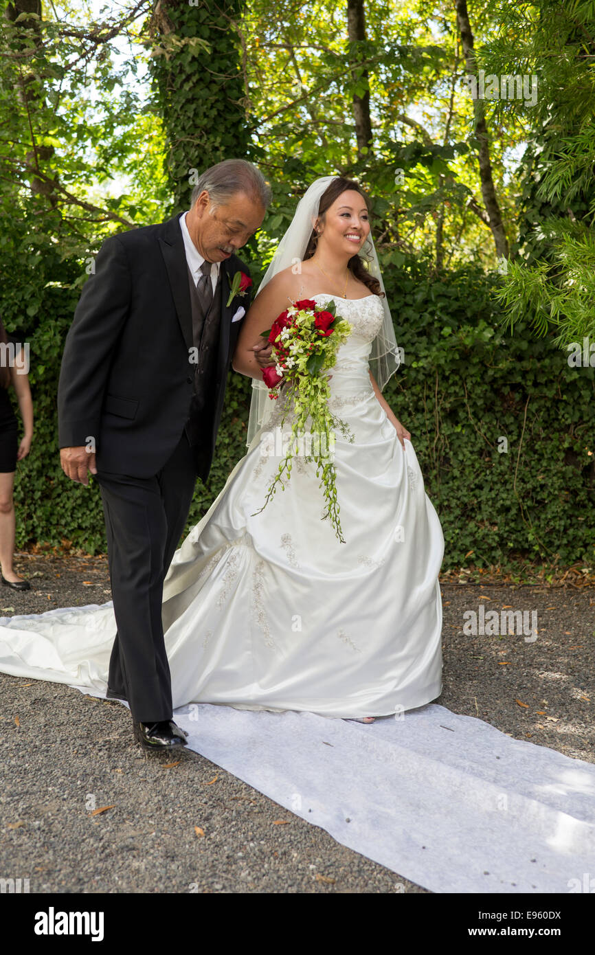 Père sa fille marche dans l'allée pendant la cérémonie du mariage à Marin Art et jardin, centre ville de Ross, le comté de Marin, en Californie Banque D'Images